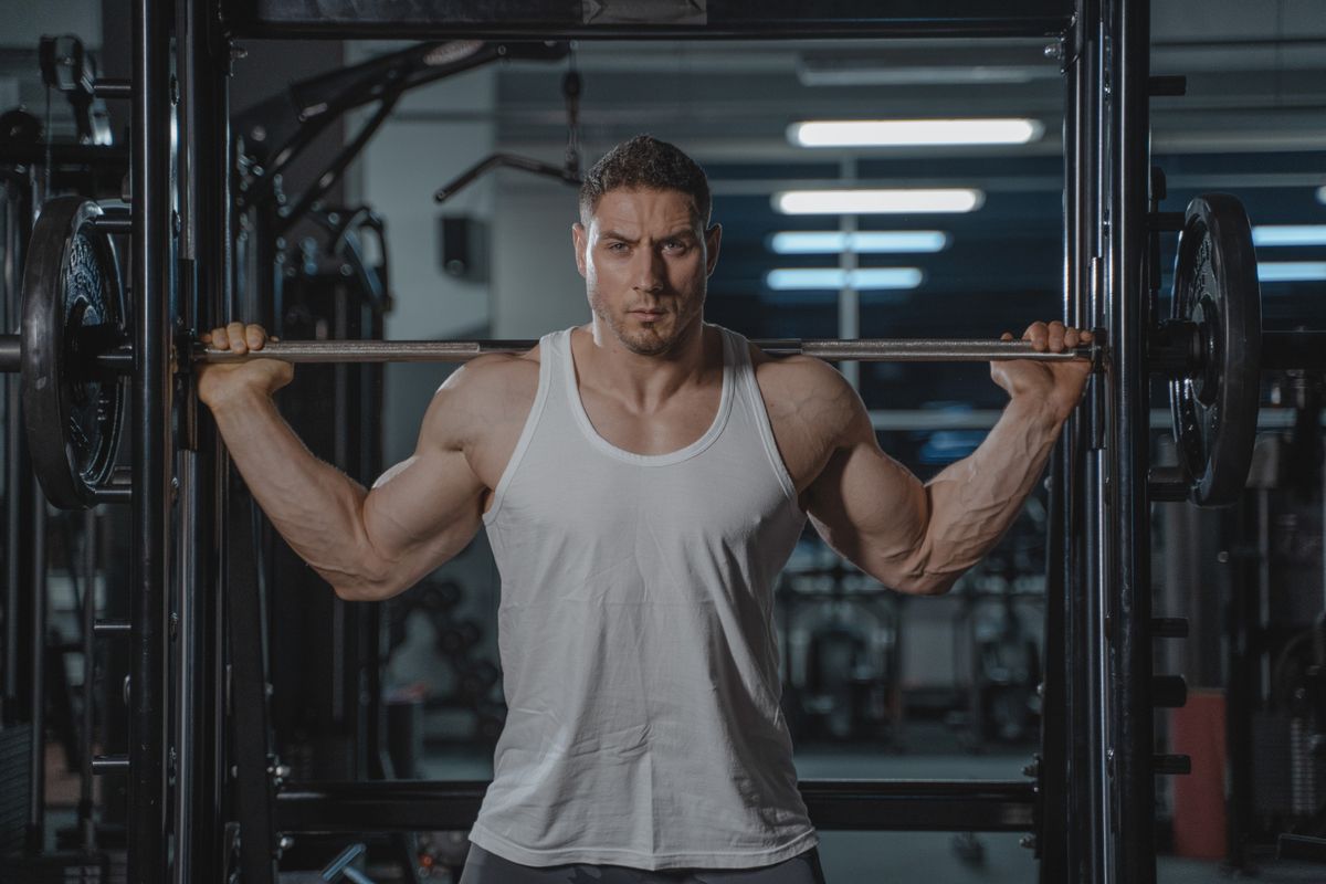 Homem adulto treinando musculação em academia